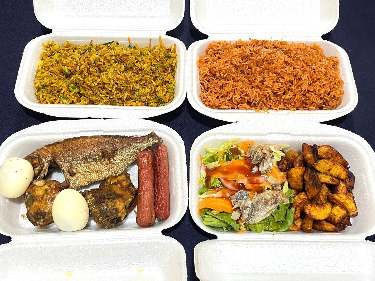 Jollof Supreme combo platter with jollof rice, fried rice, salad, gizzard, kelewele, fried fish, fried chicken, boiled egg and fried sausages